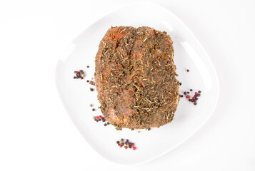 Raw pork loin seasoned - ready to be roasted, on a plate