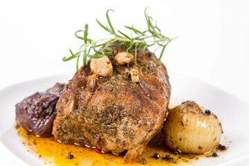 Roast pork loin with onions and garlic, decorated with rosemary and some colorful peppercorns