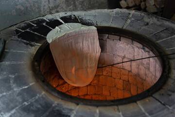 Lavash hanging on the edge of the tandoor