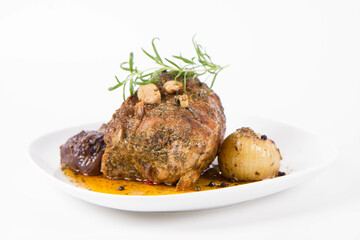 Roast pork loin with onions and garlic, decorated with rosemary and some colorful peppercorns