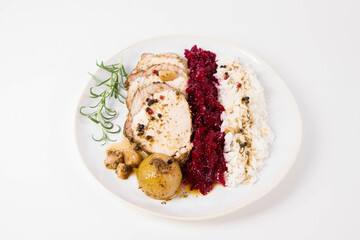Roast pork loin slices served with basmati rice and fried beets with roasted onions and garlic, decorated with rosemary 