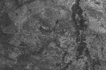 Fototapeta na wymiar Gray stone wall with dark spots and scratches. Textured stone background of gray old stone.