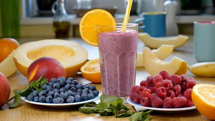 Raspberry Blueberry Melon Smoothie into a glass on the background of fresh fruits