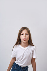 Fototapeta premium Little girl stick out tongue and look at camera