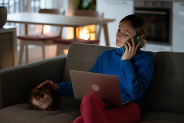 Calm female sitting on cozy sofa talk by telephone from home holding device at ear. Pensive female...