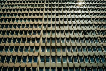 Closeup shot of a building with numerous rectangular windows, a background with geometrical patterns
