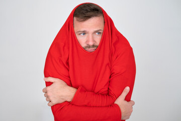 man ihiding pulling sweater on head in displeasure, keeps arms folded. 