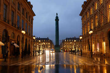 Vendome column with statue of Napoleon Bonaparte, on the Place Vendome decorated for Christmas at rainy night , Paris, France.