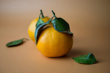 Two tangerines on an orange background.