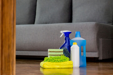 Household cleaning products and rags on floor. Chemical liquids for cleaning. Maintaining...