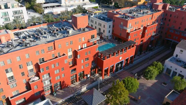 aerial footage along Arroyo Parkway with hotels, apartments and office buildings in the city skyline with cars driving on the street in Pasadena California USA