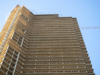 Construction of a modern high house. Building frame. Gray concrete structure. Unfinished house.