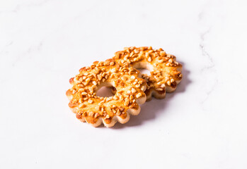 Two cookies in the shape of a ring, sprinkled with peanuts. White background
