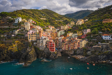 Riomaggiore, Italy - September 2022: The colorful fishing village of Riomaggiore, Italy, one of the five Cinque Terre Villages along the Ligurian Sea. Aerial drone shot