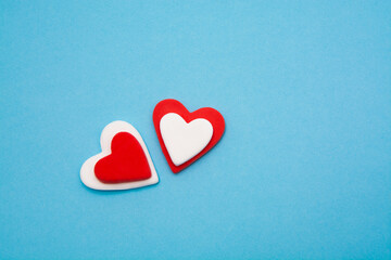 Red and white hearts on a pastel blue background. Minimal creative concept. A symbol of motherly love. Valentine's Day.