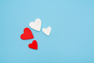 Red and white hearts on a pastel blue background. Minimal creative concept. A symbol of motherly love. Valentine's Day.