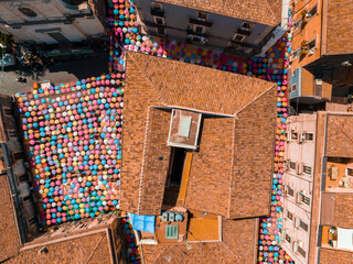 Catania Sicily Italy 2022 Street art decoration using umbrellas at the fish market, colorful view with people enjoying the food at restaurants. Aerial view.