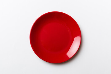 Top view of isolated of colored background empty round red plate for food. Empty dish with space...