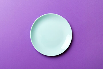 Top view of isolated of colored background empty round blue plate for food. Empty dish with space for your design