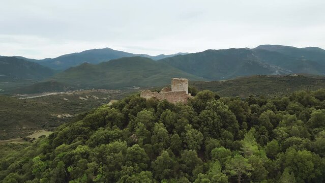 Aerial view circling Castellu di Seravalle with the Asco mountains and les Aiguilles de Popolasca in the distance