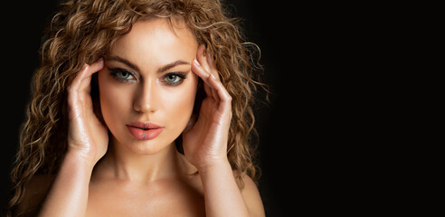 Fototapeta premium Sexy model with wavy hair and glossy skin posing at studio
