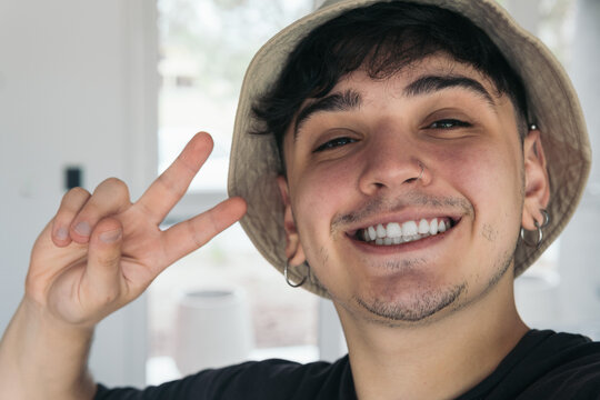 selfie of a handsome young man smiling using a hat