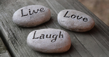 Fototapeta na wymiar Live, Love, Laugh inspirational decor pebbles