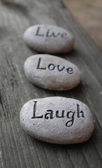 Fototapeta na wymiar Live, Love, Laugh inspirational decor pebbles 