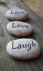 Fototapeta na wymiar Live, Love, Laugh inspirational decor pebbles 