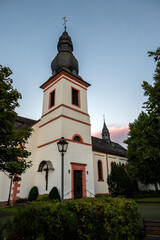 Fototapeta na wymiar Krperich, church (die katholische Pfarrkirche Sankt Hubertus) in the street