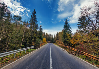 A wonderful autumn landscape of an old asphalt road in the mountains.