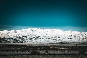 Scenic mountain range behind the clouds covered with snow