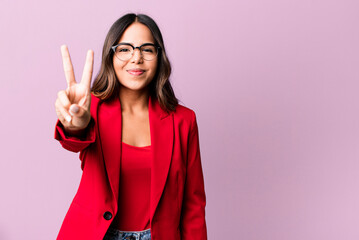 hispanic pretty woman smiling and looking friendly, showing number two. businesswoman concept