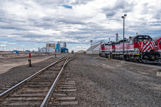 CBRW Locomotive 651 is painted red with seed processing facilities in the background at Warden, Washington, USA - June 19, 2022