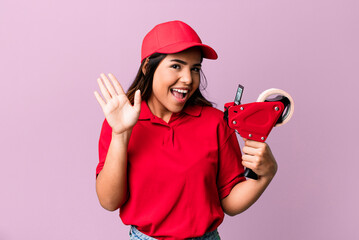 hispanic pretty woman smiling happily, waving hand, welcoming and greeting you. packer and delivery...