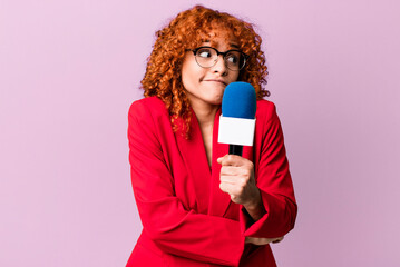 red hair pretty woman shrugging, feeling confused and uncertain. journalist and presenter concept