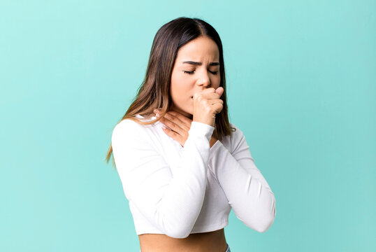 hispanic pretty woman feeling ill with a sore throat and flu symptoms, coughing with mouth covered