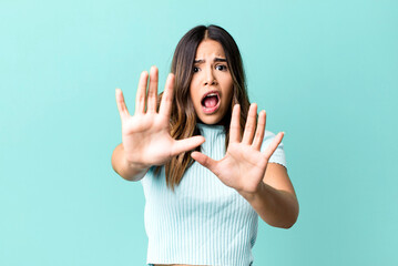 hispanic pretty woman feeling terrified, backing off and screaming in horror and panic, reacting to...