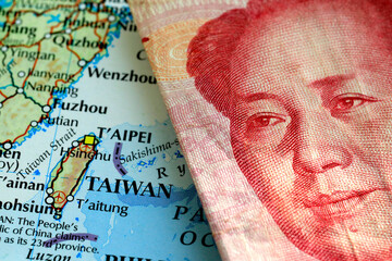 A yuan Chinese banknote on top of a map showing Taiwan