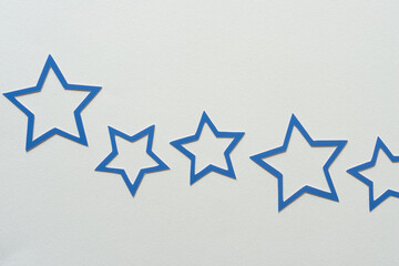 row of blue paper stars on blank paper