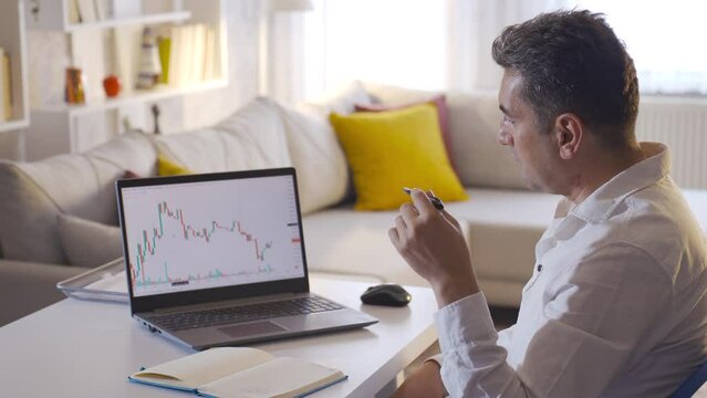The man who analyzes the daily stock market.
Man analyzing stock market charts and taking notes.
