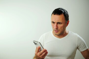 unshaven man He has some gray in his black hair Adult strict man talking on phone He is angry and...