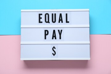 Lightbox with words Equal Pay on color background, top view