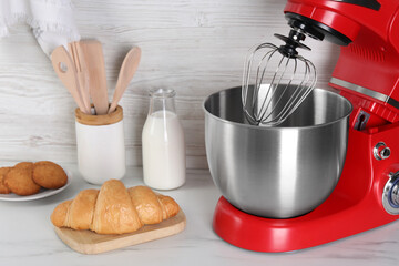 Modern red stand mixer, croissant, cookies and milk on white marble table