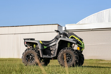 Modern quad bike in field near hangars on sunny day © New Africa