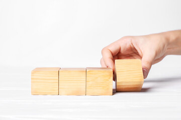 Woman arranging cubes on white background, closeup with space for text. Idea concept