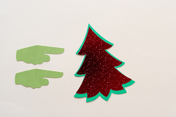 two paper hands pointing at a red metallic tree with green outline