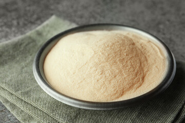 Fototapeta na wymiar Bowl of agar-agar powder on grey table, closeup