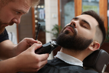 Professional hairdresser working with client in barbershop, closeup - obrazy, fototapety, plakaty
