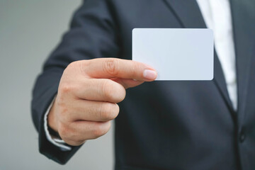 Businessman ,Business Man's hand hold showing business card - close grey background. shows business card with copy space, Show a blank piece of card.